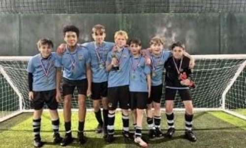 Our team of five a side football posing in front of goal posts